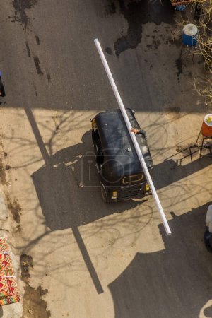 Photo for Aerial view of a tuk tuk carrying a long pipe in Cairo, Egypt - Royalty Free Image