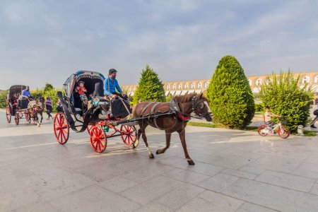 Foto de ISFAHAN, IRÁN - 10 DE JULIO DE 2019: Carruaje de caballos en la Plaza Naqsh-e Jahan en Isfahan, Irán - Imagen libre de derechos