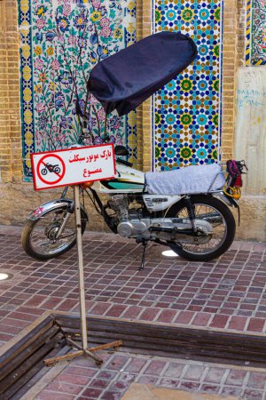 Photo for SHIRAZ, IRAN - JULY 6, 2019: Motorbike parked behind no motorbikes sign in Shiraz, Iran. - Royalty Free Image