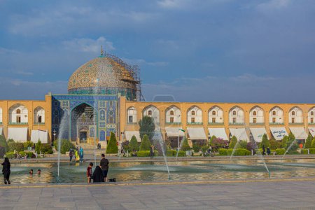 Foto de ISFAHAN, IRÁN - 10 DE JULIO DE 2019: Fuentes y mezquita Sheikh Lotfollah en la plaza Naqsh-e Jahan en Isfahan, Irán - Imagen libre de derechos