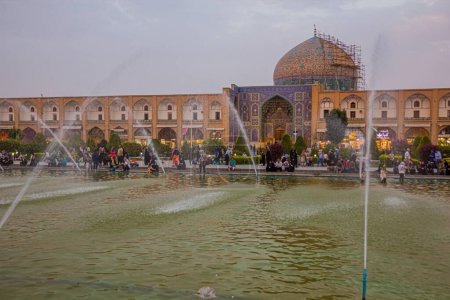 Foto de ISFAHAN, IRÁN - 10 DE JULIO DE 2019: Mezquita Sheikh Lotfollah detrás de fuentes en la plaza Naqsh-e Jahan en Isfahan, Irán - Imagen libre de derechos