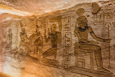 Foto de ABU SIMBEL, EGIPTO - 22 DE FEB DE 2019: Tallados en pared en el Gran Templo de Ramsés II en Abu Simbel, Egipto. - Imagen libre de derechos