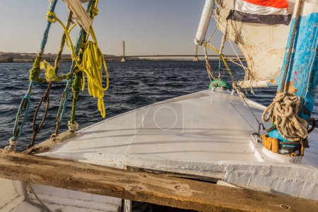 Téléchargez les photos : Felucca sail boat at the river Nile, Egypt. New Aswan Bridge in the background. - en image libre de droit