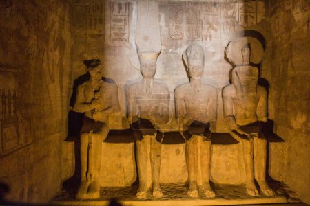 Photo for Statues of Ptah, Amun Ra, king Ramesses II and Ra-Horakhty illuminated by the rays of the sun in the Great Temple of Ramesses II  in Abu Simbel, Egypt. This phenomenon occurs only two times a year. - Royalty Free Image