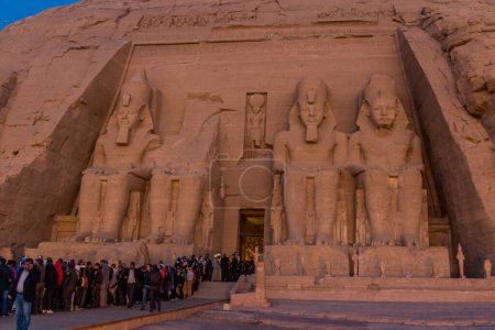 Foto de ABU SIMBEL, EGYPT - FEB 22, 2019: Long line of people waiting in front of the Great Temple of Ramesses II  in Abu Simbel, Egypt. February 22 is a special day when rays of the sun penetrate the sanctuary. - Imagen libre de derechos