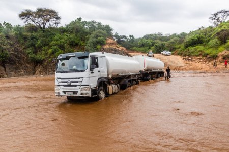 Photo for OMO VALLEY, ETHIOPIA - FEBRUARY 4, 2020: Truck stuck in swollen waters of Kizo river, Ethiopia - Royalty Free Image