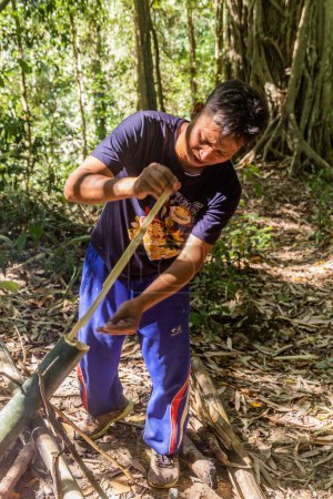 Téléchargez les photos : LUANG NAMTHA, LAOS - 18 NOVEMBRE 2019 : Guide local préparant une soupe dans une forêt près de la ville de Luang Namtha, Laos - en image libre de droit