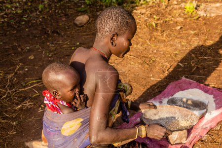 Foto de OMO VALLEY, ETIOPÍA - 6 DE FEBRERO DE 2020: Muchacha de la tribu Mursi en su aldea, Etiopía - Imagen libre de derechos