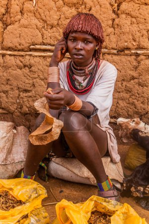 Foto de TURMI, ETIOPÍA - 3 DE FEBRERO DE 2020: Mujer de la tribu Hamer en un mercado en Turmi, Etiopía - Imagen libre de derechos