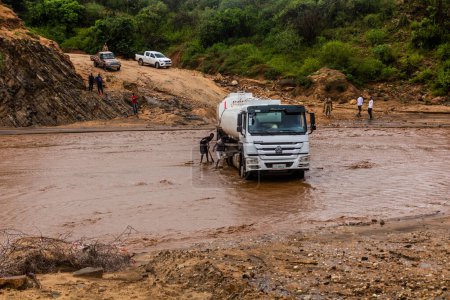 Téléchargez les photos : OMO VALLEY, ÉTHIOPIE - 4 FÉVRIER 2020 : Camion coincé dans les eaux gonflées de la rivière Kizo, Éthiopie - en image libre de droit