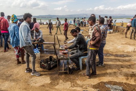 Téléchargez les photos : HAWASSA, ÉTHIOPIE - 28 JANVIER 2020 : Les populations locales et les pêcheurs avec leurs prises au marché aux poissons à Hawassa, en Éthiopie - en image libre de droit