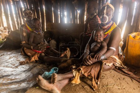 Foto de KORCHO, ETIOPÍA - 4 DE FEBRERO DE 2020: Familia de la tribu Karo en su cabaña en la aldea de Korcho, Etiopía - Imagen libre de derechos