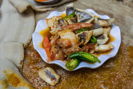 Téléchargez les photos : Repas en Éthiopie - morceaux de poisson aux piments et légumes - en image libre de droit