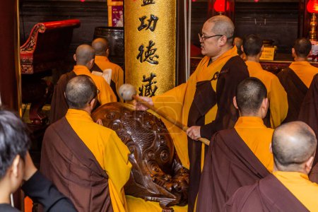 Foto de SHANGHAI, CHINA - 24 DE OCTUBRE DE 2019: Monjes budistas rezando en el templo de Buda de Jade en Shanghai, China - Imagen libre de derechos
