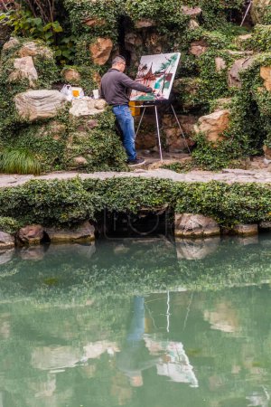 Téléchargez les photos : SUZHOU, CHINE - 26 OCTOBRE 2019 : Peintre dans le jardin Master of the Nets à Suzhou, province du Jiangsu, Chine - en image libre de droit