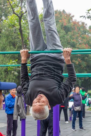 Photo for BEIJING, CHINA - OCTOBER 19, 2019: Elderly man excercises in the Temple of Heaven Park in Beijing, China - Royalty Free Image