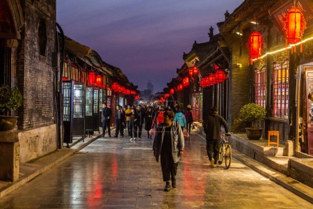 Téléchargez les photos : PINGYAO, CHINE - 21 OCTOBRE 2019 : Vue en soirée d'une rue pavée dans la ville antique de Pingayo, Chine - en image libre de droit