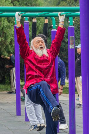 Photo for BEIJING, CHINA - OCTOBER 19, 2019: Elderly man excercises in the Temple of Heaven Park in Beijing, China - Royalty Free Image