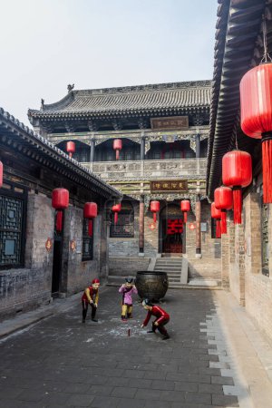 Téléchargez les photos : QIXIAN, CHINE - 22 OCTOBRE 2019 : Exposition d'enfants jouant avec un pétard dans la cour familiale de Qiao, Chine - en image libre de droit