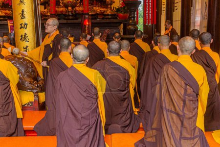 Foto de SHANGHAI, CHINA - 24 DE OCTUBRE DE 2019: Monjes budistas rezando en el templo de Buda de Jade en Shanghai, China - Imagen libre de derechos