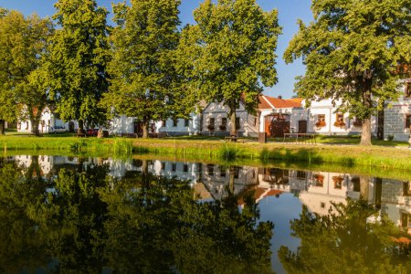 Photo for Pond and traditional houses of rural baroque style in Holasovice village, Czech Republic - Royalty Free Image