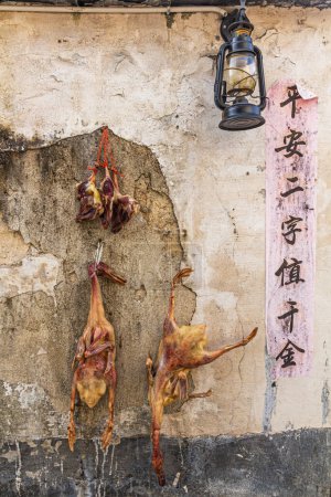 Foto de XIDI, CHINA - 29 DE OCTUBRE DE 2019: Patos colgando de una pared en el pueblo de Xidi, provincia de Anhui, China - Imagen libre de derechos