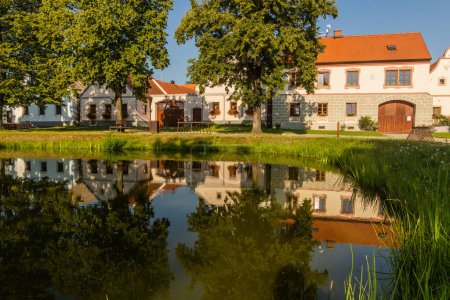 Téléchargez les photos : Étang et maisons traditionnelles de style baroque rural dans le village de Holasovice, République tchèque - en image libre de droit