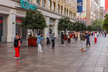 Photo for SHANGHAI, CHINA - OCTOBER 24, 2019: Elderly people excercise in the morning at pedestrian Nanjing Road in Shanghai, China - Royalty Free Image