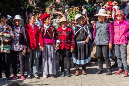 Foto de LIJIANG, CHINA - 8 DE NOVIEMBRE DE 2019: La gente local baila en el casco antiguo de Lijiang, provincia de Yunnan, China - Imagen libre de derechos