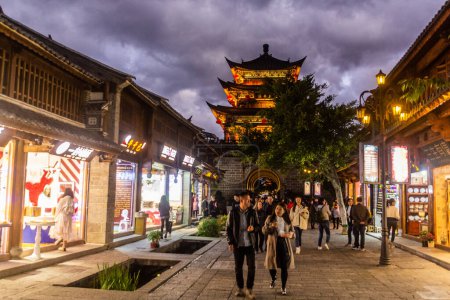 Photo for DALI, CHINA  - NOVEMBER 11, 2019: Evening view of Wuhua Tower and a pedestrian street in Dali ancient city, Yunnan province, China - Royalty Free Image