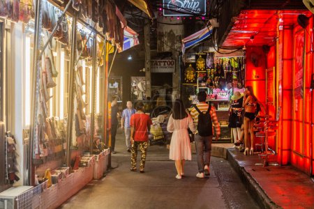 Foto de BANGKOK, TAILANDIA - 14 DE DICIEMBRE DE 2019: Vista nocturna de un callejón en el distrito de Patpong en Bangkok, Tailandia. - Imagen libre de derechos