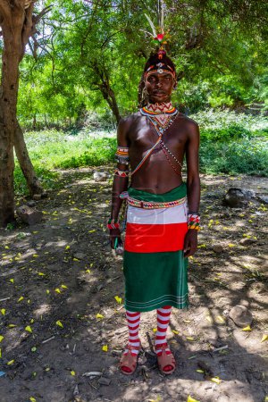 Téléchargez les photos : SOUTH HORR, KENYA - 12 FÉVRIER 2020 : Jeune homme de la tribu Samburu portant un couvre-chef coloré en plumes d'autruche après sa cérémonie de circoncision. Prise dans le village de South Horr, Kenya - en image libre de droit