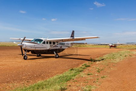Foto de MASAI MARA, KENIA - 19 DE FEBRERO DE 2020: Aviones en la pista de aterrizaje Keekorok en la Reserva Nacional Masai Mara, Kenia - Imagen libre de derechos