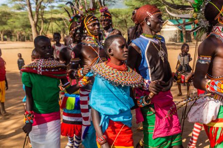 Téléchargez les photos : SUD HORR, KENYA - 12 FÉVRIER 2020 : Groupe de jeunes hommes et femmes de la tribu Samburu dansant portant des coiffures colorées en plumes d'autruche après cérémonie de malécircision. - en image libre de droit