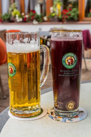 Téléchargez les photos : ALPIRSBACH, ALLEMAGNE - 1er SEPTEMBRE 2019 : Verre de bière locale Aplirsbacher Klosterbrau dans le village d'Alpirsbach, État de Baden-Wurttemberg, Allemagne - en image libre de droit