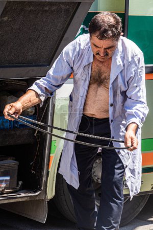 Téléchargez les photos : GABROVO, BULGARIE - 27 JUILLET 2019 : Chauffeur de bus réparé son bus dans la ville de Gabrovo, Bulgarie - en image libre de droit