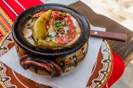Foto de El plato típico de Bulgaria - Gyuveche. Comida horneada en una olla de barro. - Imagen libre de derechos