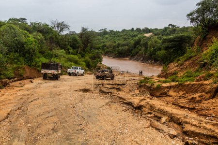 Téléchargez les photos : OMO VALLEY, ÉTHIOPIE - 4 FÉVRIER 2020 : Véhicules en attente devant un gué à travers la rivière Kizo, Éthiopie - en image libre de droit