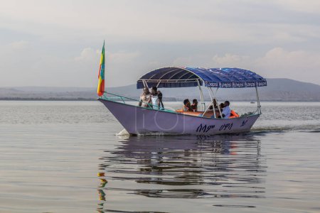 Foto de HAWASSA, ETIOPÍA - 26 DE ENERO DE 2020: Turistas en un pequeño barco en el lago Awassa, Etiopía - Imagen libre de derechos