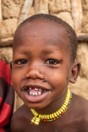 Photo for TURMI, ETHIOPIA - FEBRUARY 4, 2020: Small child in a small village of Hamer tribe near Turmi, Ethiopia - Royalty Free Image