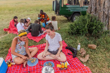 Foto de MASAI MARA, KENIA - 19 DE FEBRERO DE 2020: Participantes en un safari almorzando en la Reserva Nacional Masai Mara, Kenia - Imagen libre de derechos