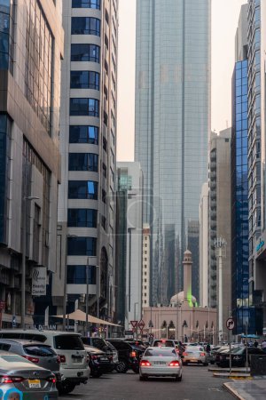 Photo for ABU DHABI, UAE - OCTOBER 18, 2021: Alley with skyscrapers and a mosque in Abu Dhabi downtown, United Arab Emirates. - Royalty Free Image