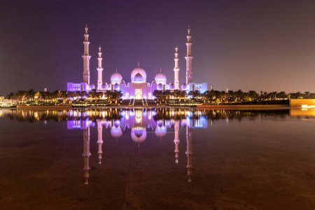 Foto de Vista nocturna de la Gran Mezquita Sheikh Zayed en Abu Dhabi reflejándose en el agua, Emiratos Árabes Unidos. - Imagen libre de derechos