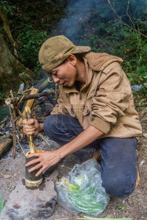 Foto de NAM HA, LAOS - 16 DE NOVIEMBRE DE 2019: Guía local preparando una comida en el bosque del Área Nacional Protegida de Nam Ha, Laos - Imagen libre de derechos
