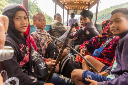 Téléchargez les photos : NAM OU, LAOS - 24 NOVEMBRE 2019 : Garçon local avec une arbalète sur un bateau à la rivière Nam Ou, Laos - en image libre de droit