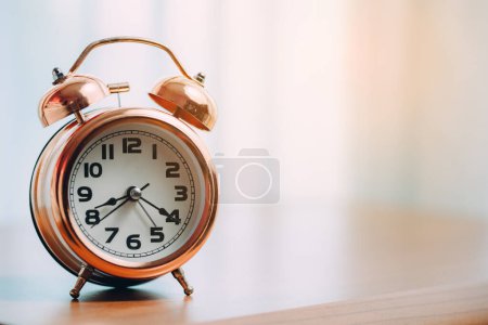 Foto de Reloj despertador de campana vintage sobre la mesa para el concepto de gestión del tiempo. - Imagen libre de derechos