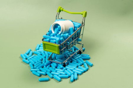 cápsula de medicina azul en miniatura carrito de la compra para simbolizar la compra de medicamentos