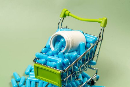 cápsula de medicina azul en miniatura carrito de la compra para simbolizar la compra de medicamentos