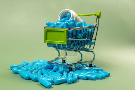blue medicine capsule in miniature shopping cart to symbolize medicine purchase