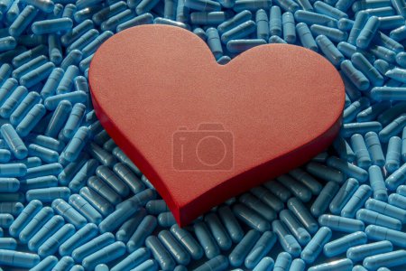 many blue medicine capsules and heart shape symbolizing medical activity